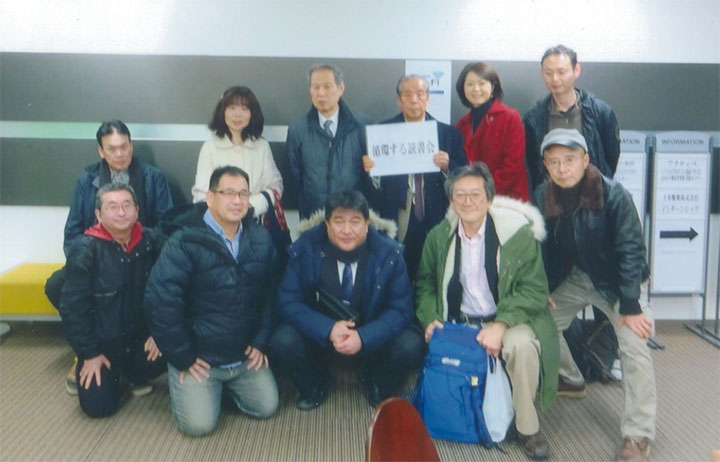 飛松さんが案内板を持ってます