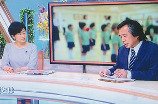 「教育勅語」を暗誦する幼稚園児（後ろ）のテレビ