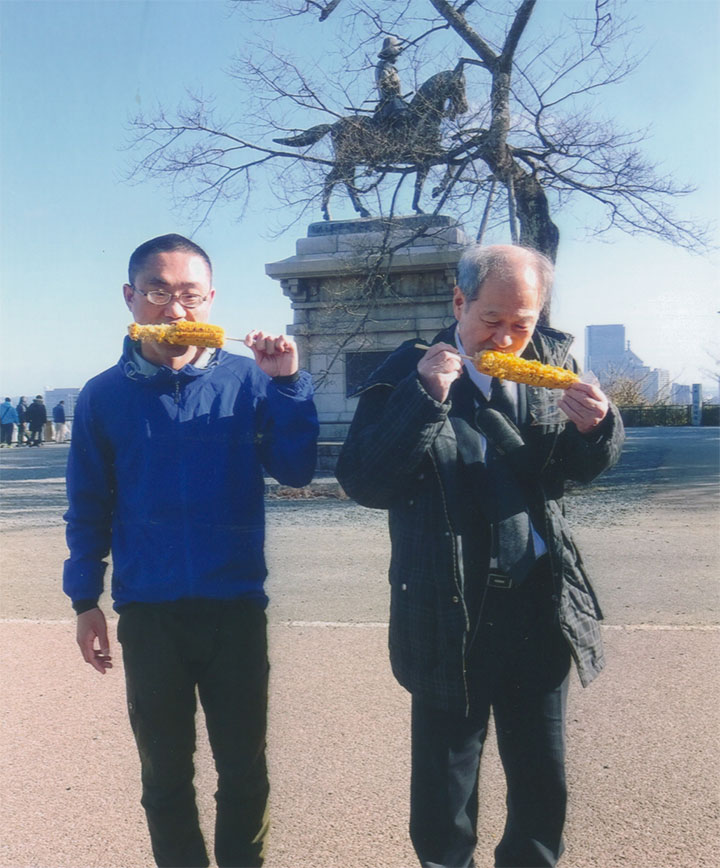 トウモロコシを食べる二人