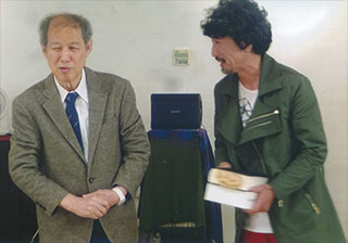 笠井さんの本を持つ高木氏