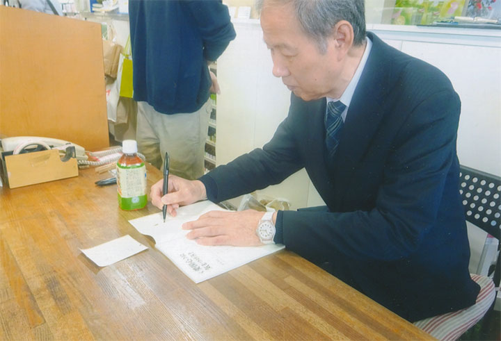 サインをしてます