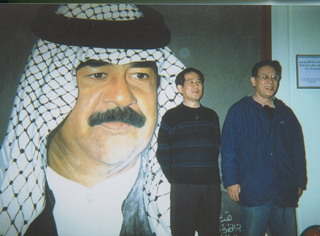 イラクで。フセインの肖像画の前で。塩見孝也さんと