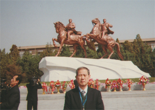 主席、総書記の銅像の前で