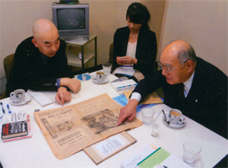 当日の新聞を前に説明する寺尾さん