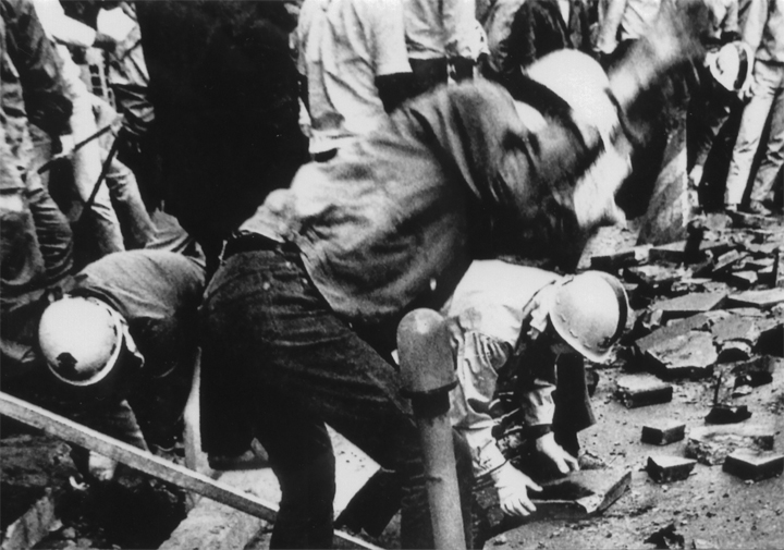 舗道を剥がして石を投げる学生